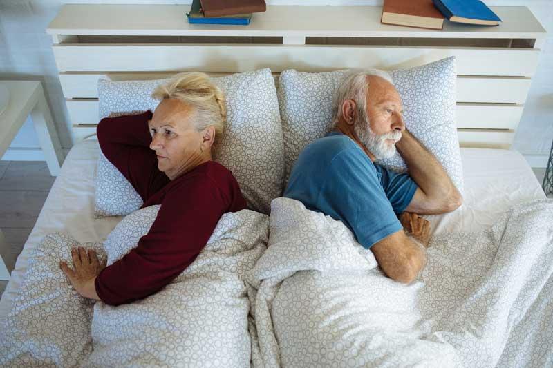 frustrated older couple in bed